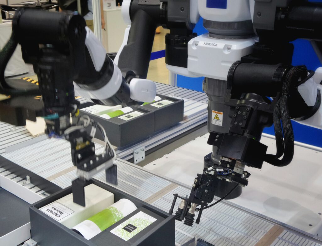 Robotic arm with vision camera system picking and placing packaged products on an automated production line in a manufacturing facility
