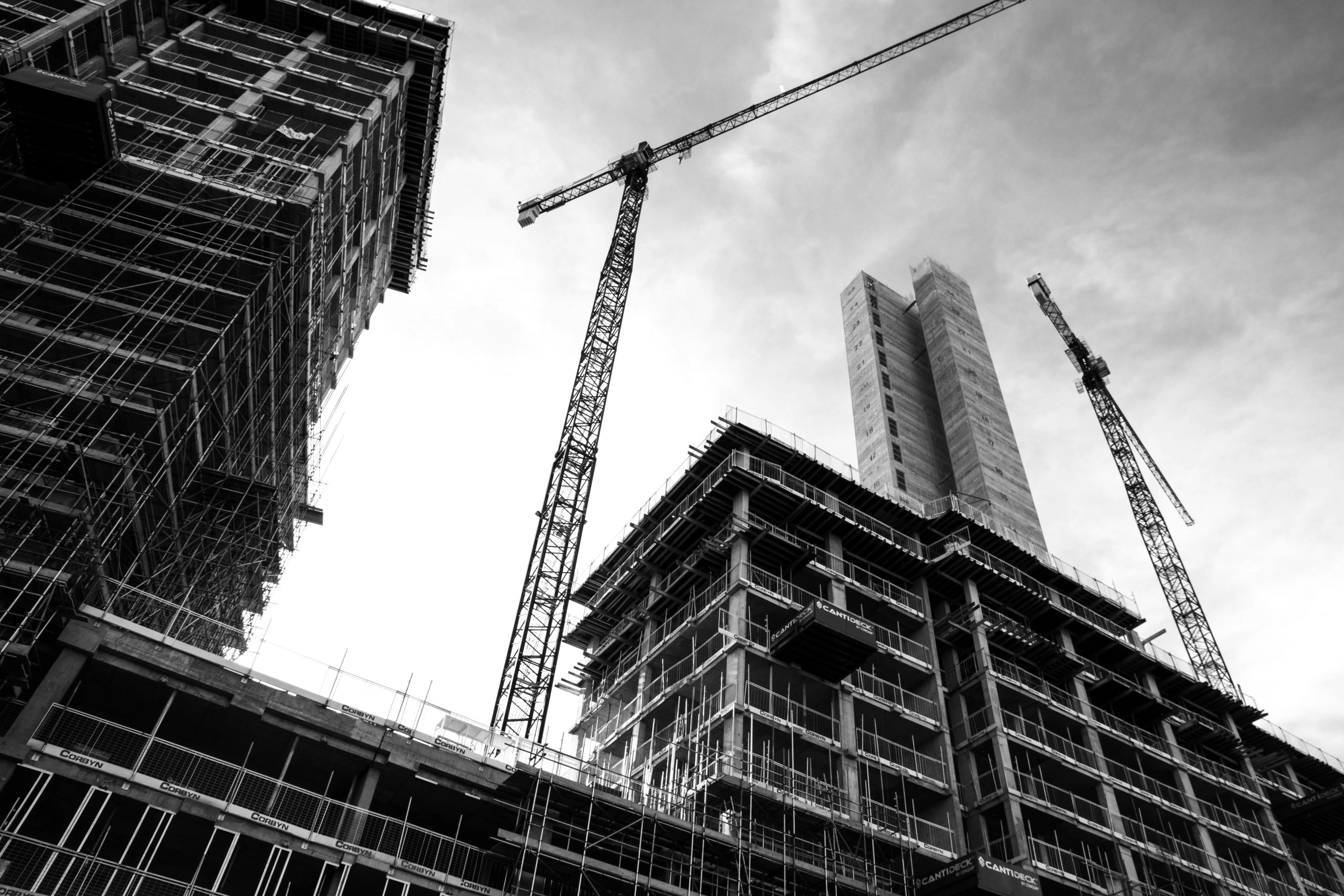 Black and white image of construction site with crane and building under development