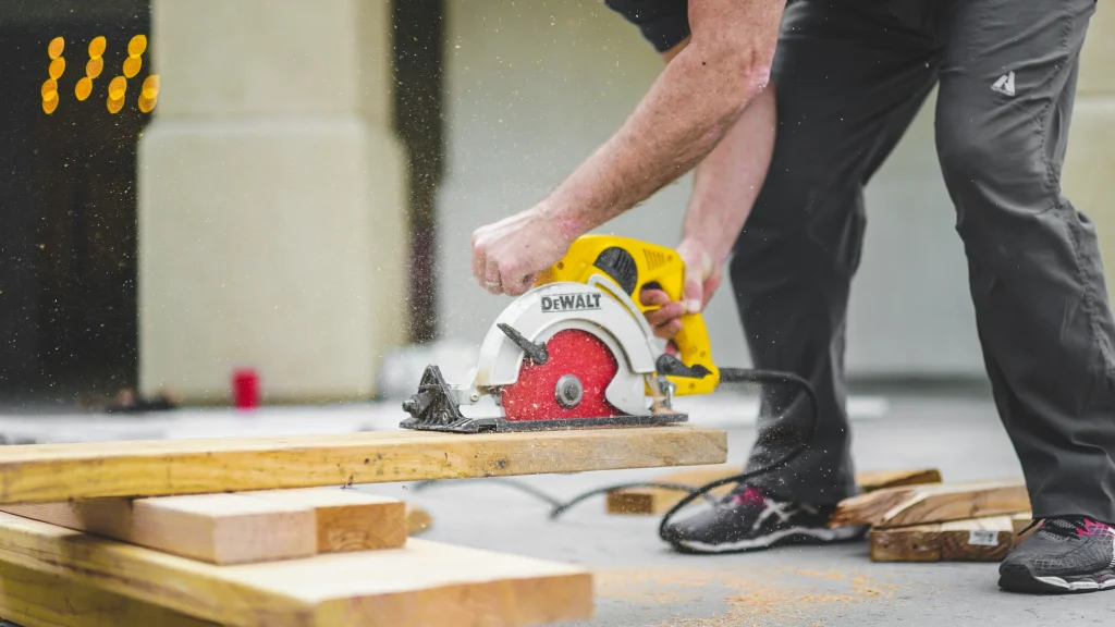 Construction worker sawing a wooden plank with a disc saw