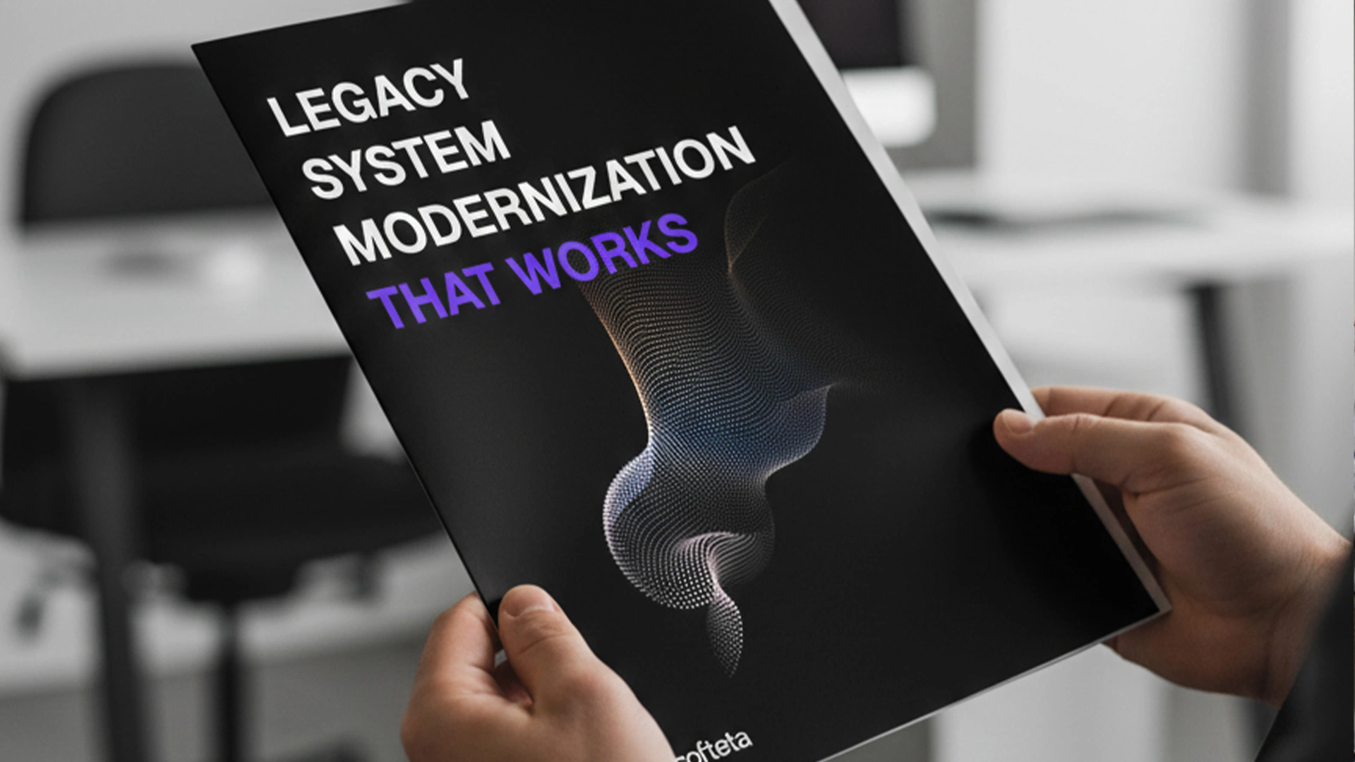 Hands holding Softeta whitepaper titled Legacy System Modernization That Works