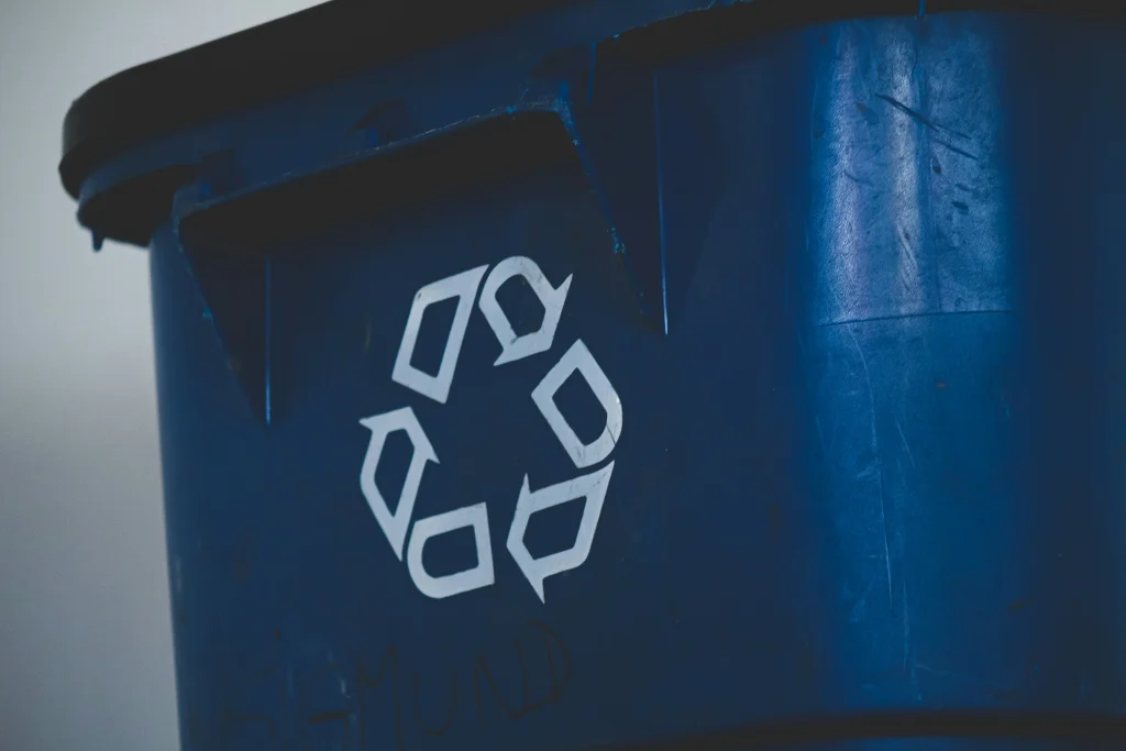 Trash can with a recycling logo