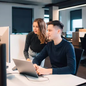 Two Softeta team members looking at a computer screen