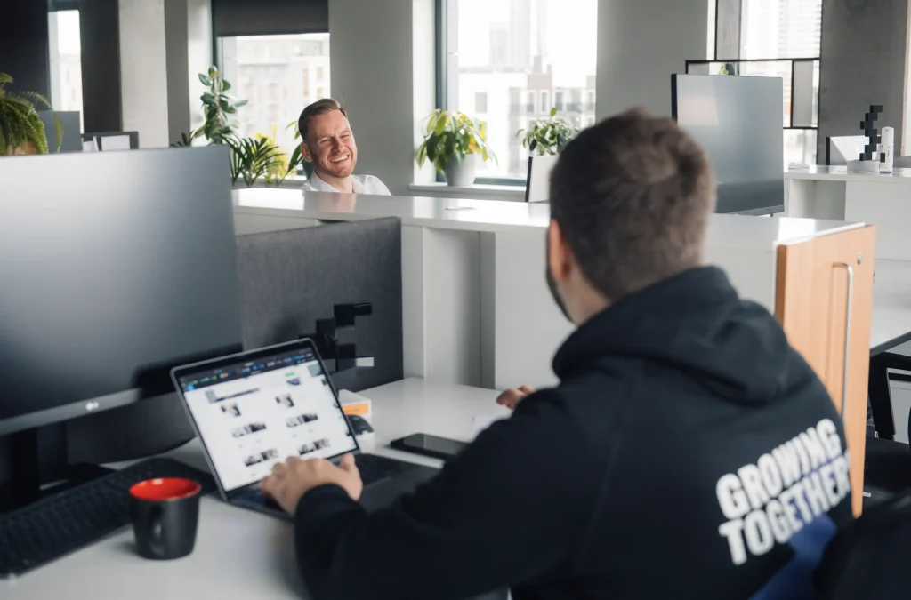 Softeta colleagues having a casual video meeting with laptop in modern office space with plants