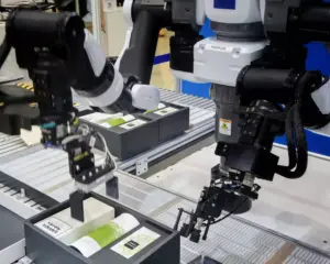 Robotic arm with vision camera system picking and placing packaged products on an automated production line in a manufacturing facility