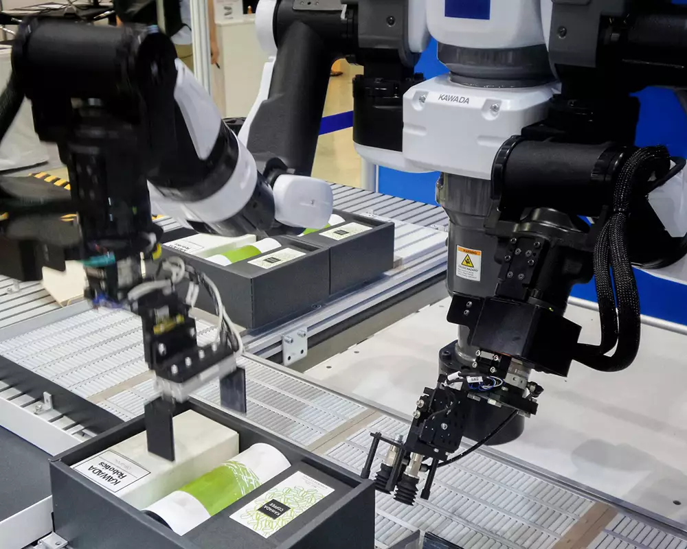 Robotic arm with vision camera system picking and placing packaged products on an automated production line in a manufacturing facility